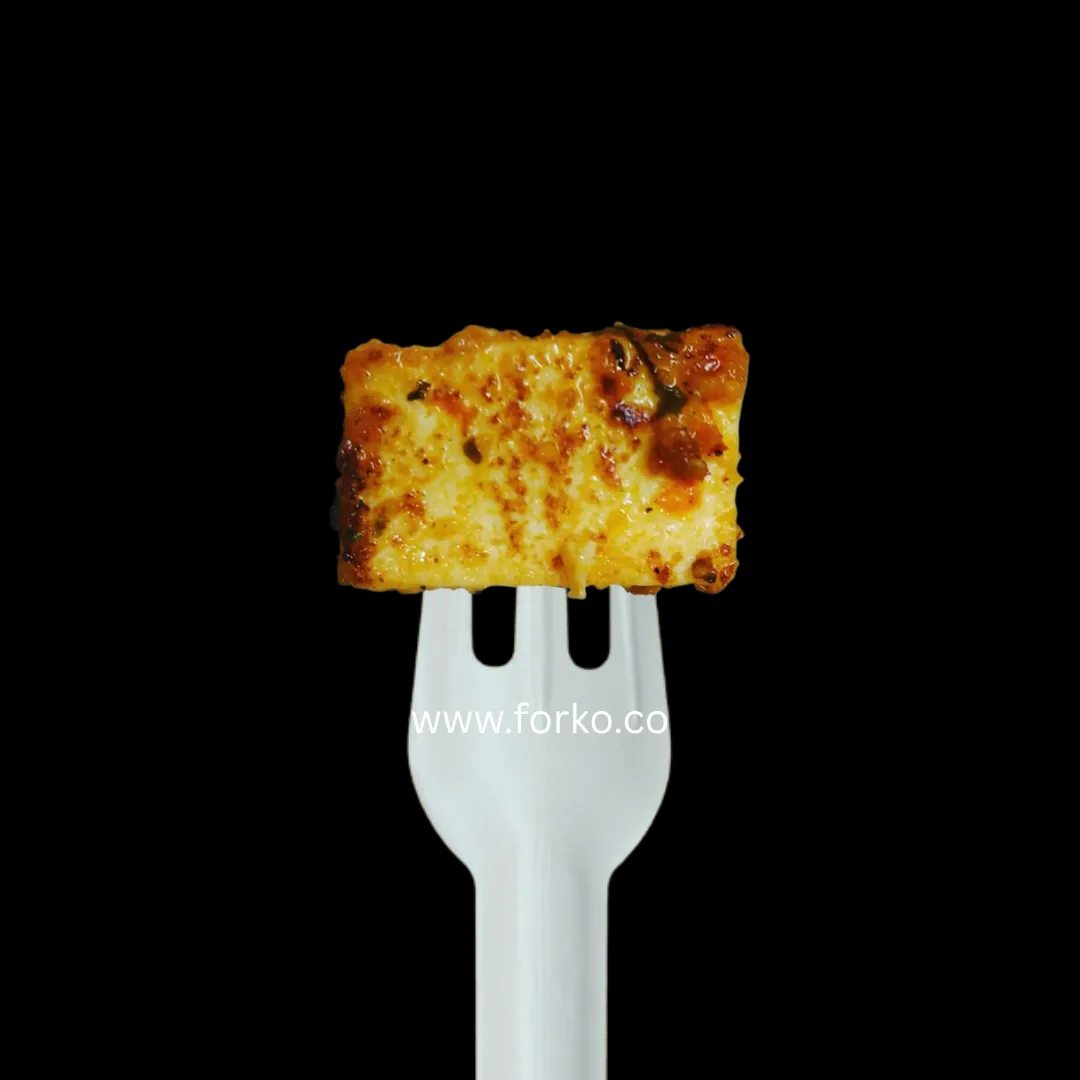 Paper fork holding a piece of grilled paneer